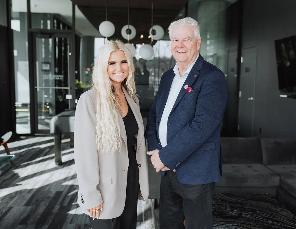 Cam and Jill Bird, Saskatoon REALTORS&reg; with RE/MAX, standing together in a modern condo lobby
